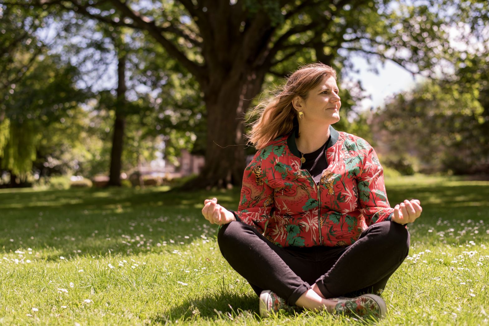 Laura Hamblyn healer, sitting crossed legged in a park