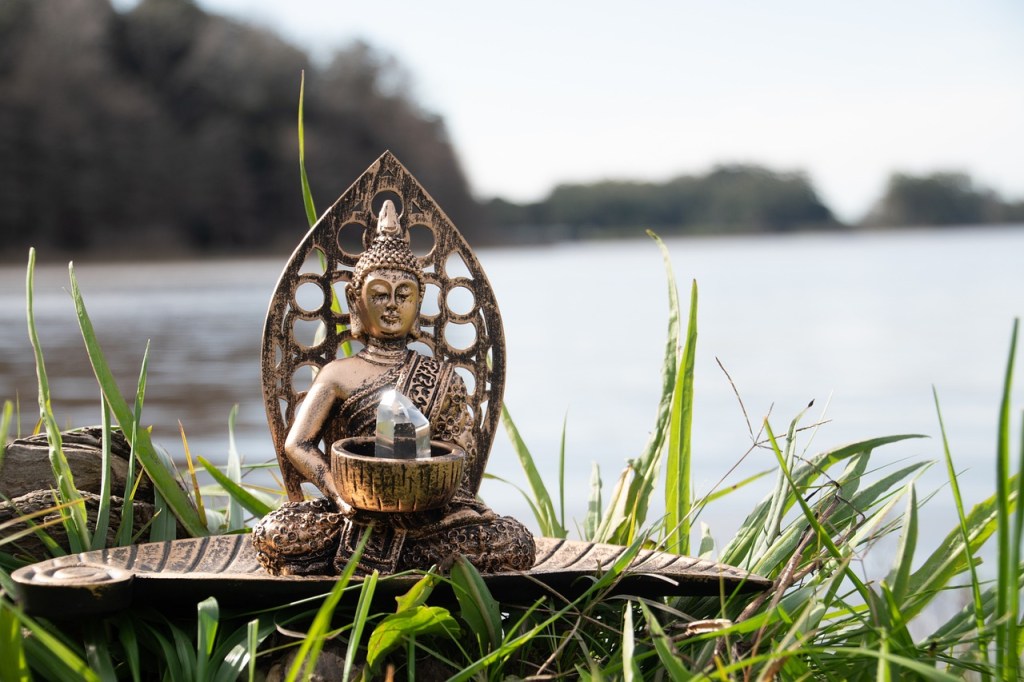 Image of a mertie of buddha sitting by the river 